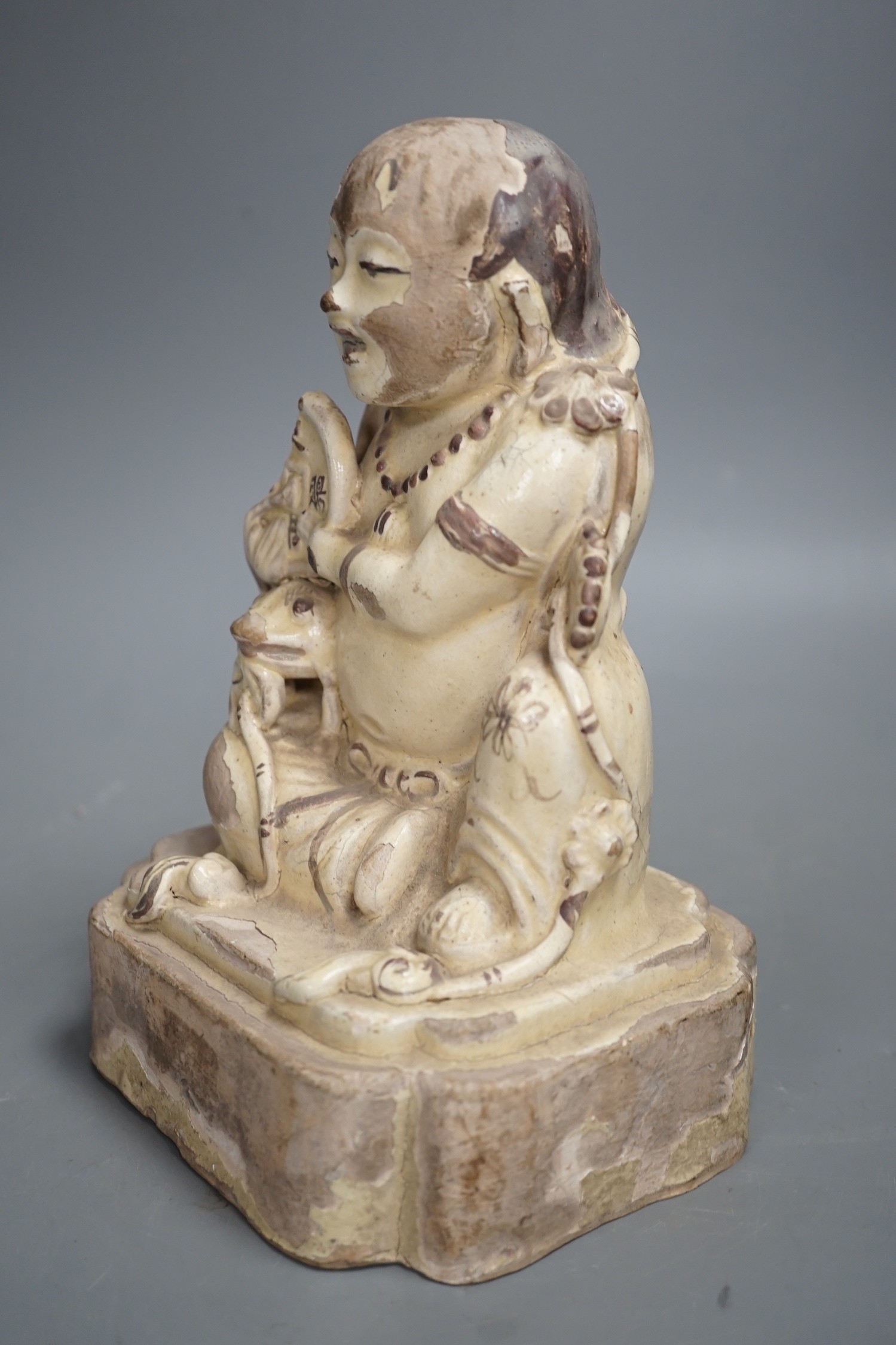 A Chinese Cizhou seated figure of Liu Hai, possibly Ming dynasty, 21cms high, glaze flaking